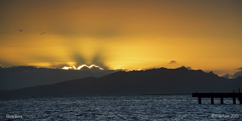 Horizonte 03.jpg - early morning view from the east shore of the island ofBora Bora (Polynesie française) towards Raiatea and the risingsun above a bank of morning clouds.   click here for Google Maps View   Position (camera): S16°32'31" W151°44'08", elev. sealevel Camera: Nikon 200 at 116mm, date: 05/11/2010, 05:34 local