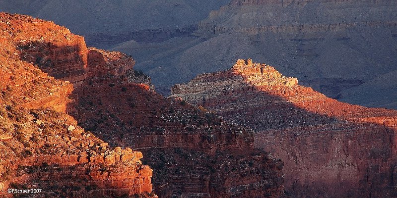 Horizonte 102.jpg - made on a very early walk along the South Rim of Grand Canyon in Arizona. The rising sun enlighted the reddish rocks but left the lower part of the canyon still in a deep shadow.   click here for Google Maps View   Position (camera): N36°03'32" W112°07'32", elev. 2130m/7000ft Camera: Nikon D50 at 135mm, date: 07/03/2007, 06:45 am