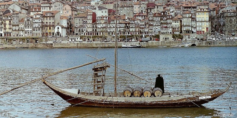 Horizonte 128.jpg - "Mr.Sandeman", a wooden figure as advertisingon a old Sherry-boat in the Douro-river, flowing throughthe old town of Porto, Portugal. Sandeman is a wellknownproducer of Sherry and Portwines, founded in the year 1790. I made this pic 1982 on Ektachrome-film and digitalized it.Therefore the quality is not comparable with new digitals...  Position: N41°08'17" W08°17'00" about sealevel. Camera: Minolta X700 w.1,8/35mm, date 12/06/1982