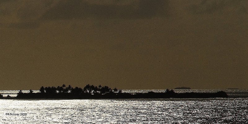 Horizonte 198.jpg - standing on the reling of our freighter in thevery early morning I made this fascinating backlightingexposure of a Motu (small coral island) viewing into the93 km2 lagoon of Takaroa in the Tuamotu-Archipel, 650 kmnortheast of Tahiti.   click here for Google Maps View   Position (camera): S14°29'08" W145°03'40" at sealevel Camera: Nikon D200, 200mm lens, date: 21/11/2010, 06:03am local