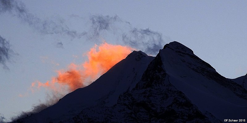 Horizonte 254.jpg - the peak of the Weisshorn (Wallis, Switzerland) witha glowing Cirrus-cloud, illuminated by the very last sunrays. I madethis picture from the Village of Graechen, about 14 km or 9 mi away.The first ascent of this 4505m-peak occurs 1861 by John Tyndall andhis two Swiss guides.   click here for Google Maps View   Position (peak): N 46°06'05"/E 07°42'58", elev. 4505m/14820ft. Camera: Sony HX400 with Zeiss Sonnar, date: 21/10/2016, 17:34 local.