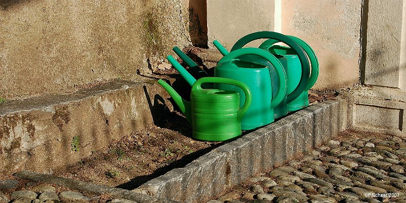 Horizonte 304.jpg - Watering-cans waiting for the Gardener just beside theentrance to the historic church "Santa Maria del Sasso" (1462-17)in Morcote, a pittoresque Village in southern Switzerland.   click here for Google Maps View   Position: N45°55'23"/ E08°54'50", date: spring 2007, not recordedCamera: Nikon D50, Nikkor 35-135