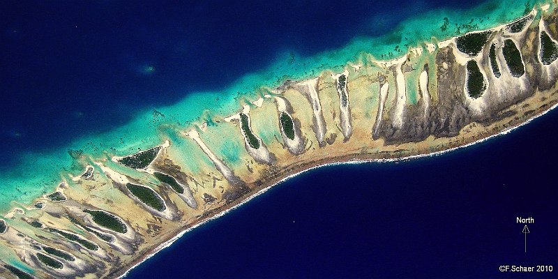 Horizonte 343.jpg - on a low flight from Tikehau to Rangiroa (French Polynesia)I had a great viev of a section of the circular Atoll of Tikehau. Thevisible part is about 3,5km long, the whole ring may contain hundredsof such tiny, sandy islets, covered with coconut-trees and underbrush.The coral-banks within the lagoon appears bright greenish.Position: S 15°03'26"/W 148°06'17", flying altitude about 4500ft ASLCamera: Canon Ixus 80, date: 07/11/2010, 12:02pm