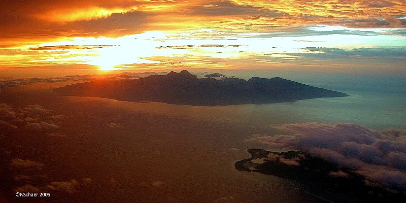 Horizonte 87.jpg - after a very long night-flight (8:50hrs) from Los Angeles we approached our destination Tahiti at sunrise. This impressive view from the aircraft shows the islands of Tahiti and Moorea in the foreground. Mt.Orohena (center, 2240m/7350ft) is the highest mountain in French Polynesia.   click here for Google Maps View   Position (camera): S17°22'35" W149°54'28", estimated alt.2350m/7730ft Camera: Nikon Coolpix 995 date: Nov.2005